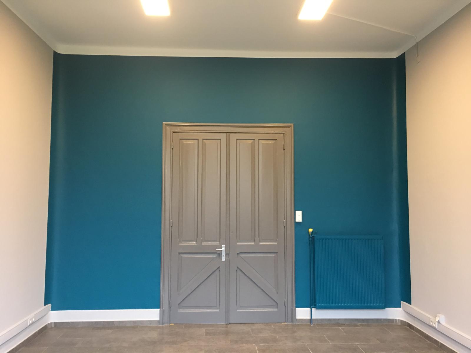Salon avec mur d'accent teal et double porte beige