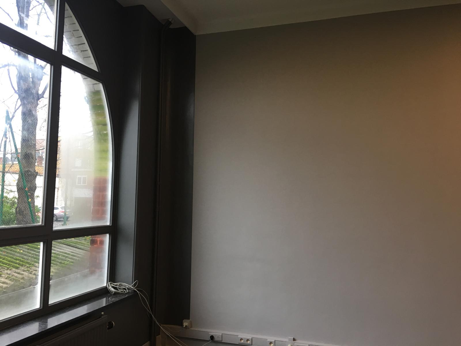 Peintre sur échafaudage devant un lustre